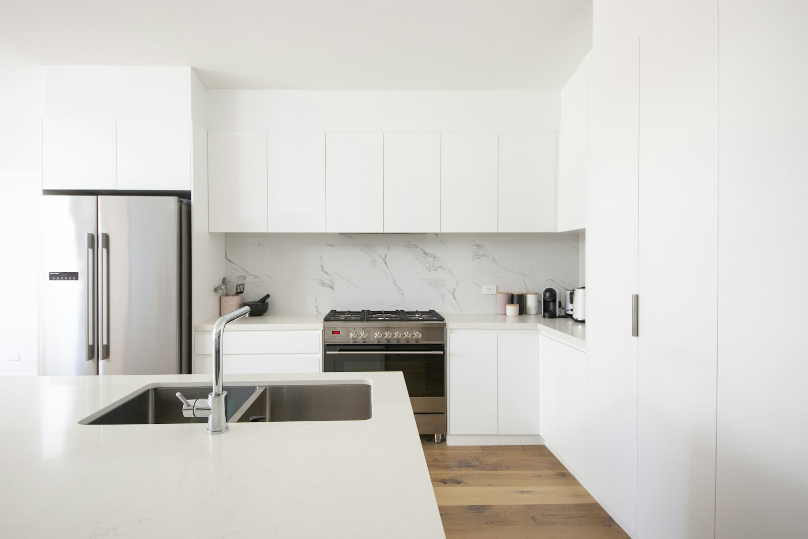 Clean renovated kitchen with white cabinets and natural light